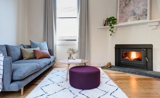 A simple material palette of polished concrete, white surfaces, and timber details create a light, warm, neutral space that’s enhanced by colorful artwork and homeware—and plenty of natural light. 