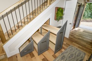 The cabinets under the stairs are ideal for shoe racks.