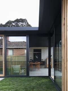 The extension sits on a burnished concrete slab with exposed concrete bricks along the main wall. 