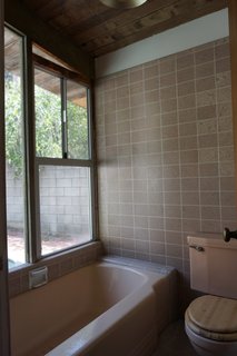 "The master was the biggest challenge. It was a divided space with a vanity area that was open to the bedroom. A small separate (carpeted!) room held a shower-over-tub with a rotted window over it, and the toilet. We removed the dividing wall and put a freestanding tub and put beautiful Heath tile behind it as a focal point," says Martin.