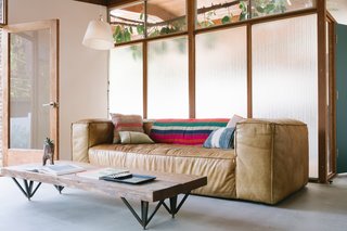 A RH Fulham leather sofa, a Garza Marfa striped blanket and HD Buttercup cushions.