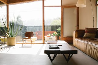 A custom reclaimed wood and car jack coffee table and an Eames LCW chair.