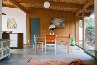 Air Force atomic vintage dining chairs, and a custom dining table made from oak and safety glass.