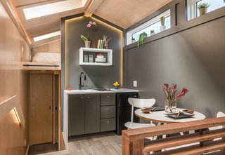 The kitchen and dining area is located on a raised platform in between the bathroom, bedroom, and living lounge.