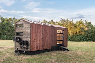 They tiny house connects to the outdoors with clerestory windows, floor-to-ceiling windows, skylights, and a garage door that opens up an entire wall.