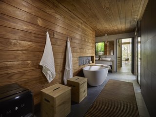 Wooden surfaces give the bathroom and sauna a warm, spa-like feel. A fully glazed wall connects the sauna to the great outdoors. 