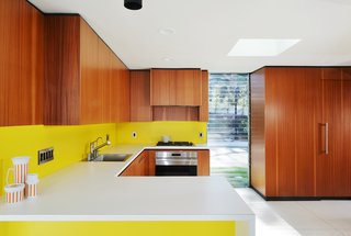Walnut veneer walls warm up and unify the open-plan spaces.