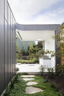 Irregular stone pavers lead to the outdoor grill.