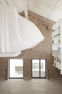 A floating bookshelf lies across from the sleeping area.