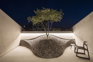 A Zen rock garden on one of the balconies with a Vitra Tip Ton chair.