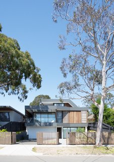 The facades of Kew East House are banded with interlocking, metal panel fascias that weave it into the streetscape. 