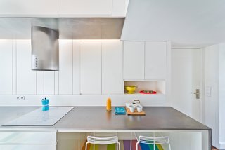 Minimalist Hee Bar stools by Hee Welling are tucked underneath the counter.