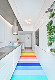 In the kitchen, a mini vertical garden provides fresh aromatic herbs thanks to a mix of direct sun and specialized artificial lighting. A vibrant rubber floor leads the eye forward.