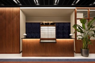 The reception features terrazzo flooring and teak and walnut casework.