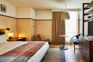 Walnut and black metal millwork in a guest room, and lamps in the guest rooms designed by Gachot.
