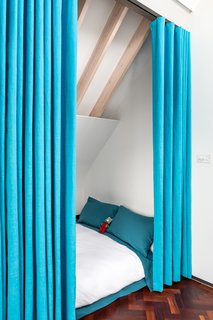 A child's sleeping area has curtains for privacy.