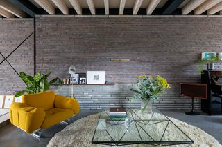 The living room features an exposed brick wall and ceiling beams.