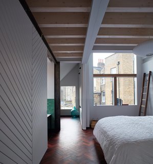 Large windows bring sunlight into the bedroom.