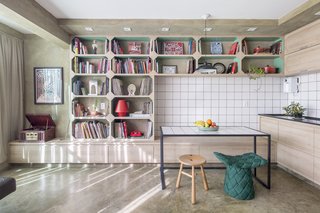 The white tiles of the kitchen are also used for the surface of the iron-frame dining table.