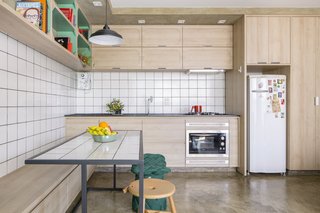 A white tile backsplash sets the kitchen and dining apart from the concrete and wood walls in the rest of the home. 