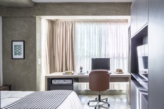 The gray partition has a TV shelf on the side that faces the bed.