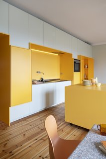 A VOLA KV series kitchen faucet extends from the wall.
