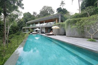 Sited on a steep hill overlooking lush tropical jungle and a river, this private villa is set on different levels that appear as if they are part of the natural landscape. The architecture follows the contours of the land, allowing for in-between spaces and gardens that would otherwise be difficult to enjoy.