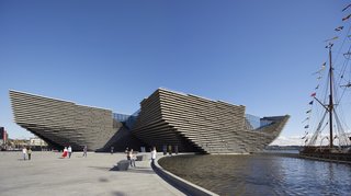 The façade of the Scotland branch of London’s renowned Victoria & Albert Museum was created with multiple horizontal, precast concrete layers in homage to the country’s stunning cliffs. A horizontal opening in the center allows the street to stay connected with the River Tay, helping the building integrate with its environment. 