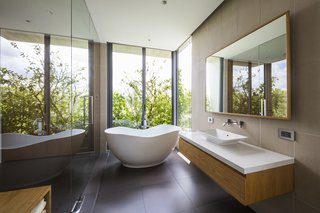 A freestanding tub, placed near a window, enjoys a green view as well as privacy.