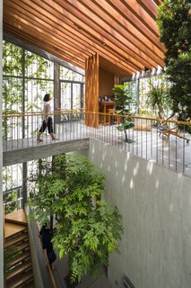 The 5,081-square-foot dwelling features a large void at the center that cuts diagonally through all three floors. "We intentionally designed the house as a continuous stepping park from the first to third floor in order to bring the greenery into the living spaces," says Vo.
