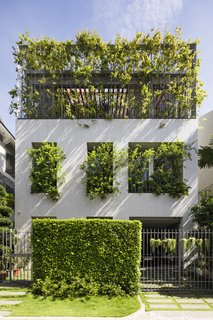 The permeable top floor allows greenery in to the home to spill out toward the neighborhood.