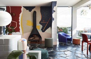 Energetic artwork replaces the typical entertainment unit found in most living rooms. 