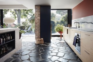 A brick plinth serves as a kitchen island. Below lies an integrated mini bar.