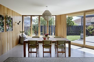 Floor-to-ceiling windows on both sides of the living area create the illusion of a continuous, open space. Concrete floors help with passive cooling.