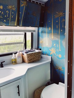 The bathroom walls feature Justina Blakeney Cosmic Desert Wallpaper from Hygge & West.