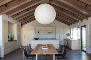 Within the great room are a modern kitchen, and generous dining and living spaces with retractable glass walls that open to the atrium and a 68-foot, infinity-edge pool. 