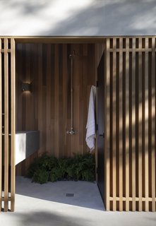 An outdoor poolside shower and toilet.
