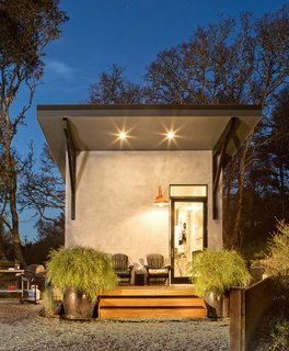 An orange lantern lights the way to an angular gray structure.