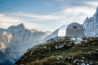 Based on the 1936 design of a bell-shaped metal alpine shelter, "Bivak II na Jezerih" was updated for modern use with an interior outfitted in wood and designed to accommodate the area's harsh climate: hurricane-force winds, several meters of snow, and general water and sun exposure. The shelter can accommodate up to six people with a folding table, overlapping bench, and other multipurpose pieces.