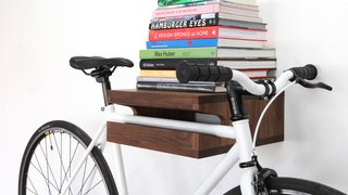 10 Ways to Solve Storage Problems in Small Spaces - Photo 2 of 10 - Finding a place to store larger items that are used daily is challenging. Thankfully, a beautifully crafted shelf like this from Knife and Saw elevates (both literally and figuratively) your commuter bike to the realm of sculptural art. It also provides room for your coffee table books. 