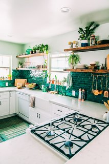 These green tiles are a perfect backdrop for the wealth of potted plants lining the shelves and window sills in this L.A. artist's kitchen. 