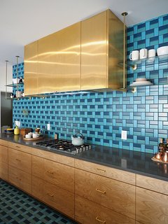 This kitchen, from the 2015 Sunset Idea House, features a pattern of blue & turquoise tiles from the back wall all the way to the kitchen floor. 
