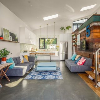 The interior of the space is filled with natural light, thanks to the vaulted ceiling and skylights. The owner's workspace resides in an upper loft—a volume highlighted by salvaged wood panels. 