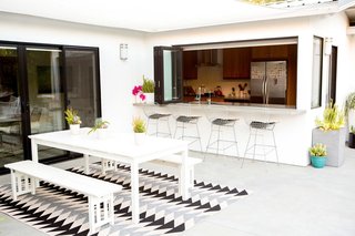 Bring asphalt patios and concrete backyards alive with rugs, plants and monochromatic color palettes.