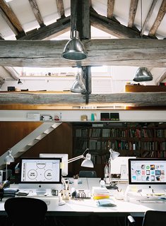 This multi-level attic is home to a creative firm that use the lower space for its production studio and the upper space for meetings or traditional work. 
