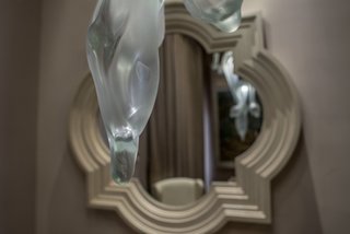Contemporary glass fixtures with fluid, natural shapes harmoniously blend with the more traditional elements found in throughout the house. 