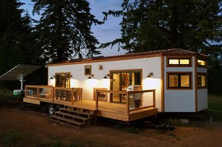 This tiny house on wheels is by Tiny Heirloom. To make the home more eco-friendly, the owner installed a solar panel nearby to generate power.