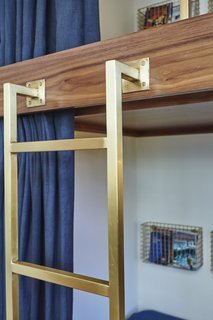 Sarah Barnard designed the custom brushed brass ladder and bed rail to complement the antique metal finishes.