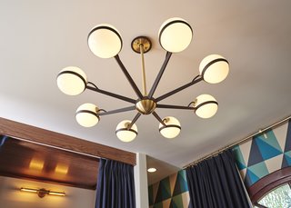 The vintage inspired brass and black chandelier makes the room glow with warm diffuse light.
