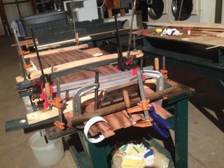 Clamping the deck and bottom to the skeleton by all means necessary—threaded rods, G-clamps, strips of PVC pipe, and later, those water bins on top.